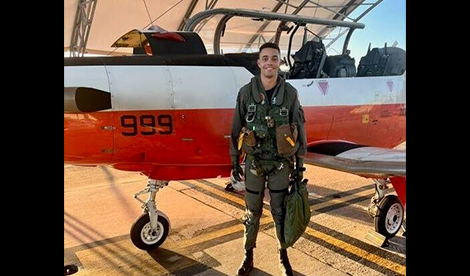 Chris Sims stands in front of his plane